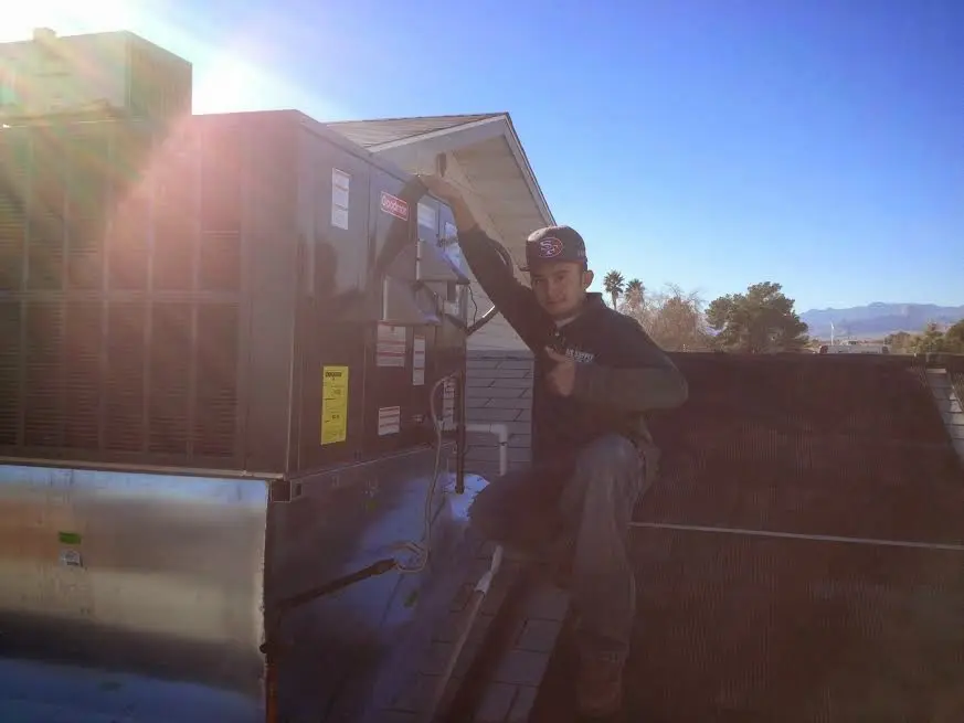 HVAC technician performing Boiler Repair on a rooftop unit in Flagler Beach